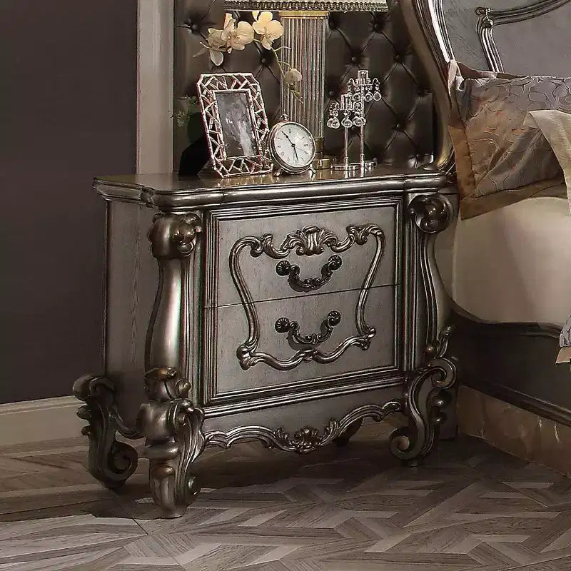 Comodino antico in platino con intagli ornamentali e vani multi-cassetto